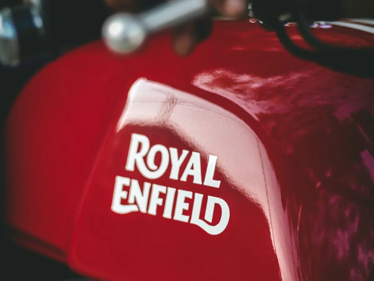 Červená nádrž motorky Royal Enfield s bílým nápisem